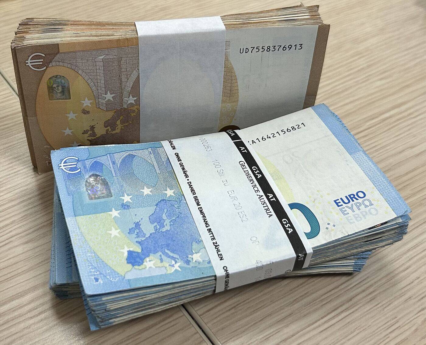 Gebündelte 20- und 100-Euro-Banknoten auf einem Schreibtisch