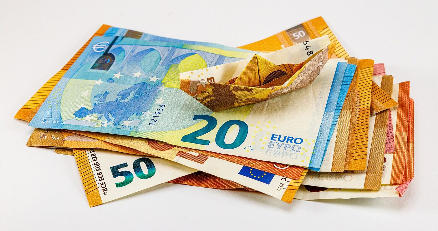 A fanned spread of euro banknotes with one note folded and standing out from the rest